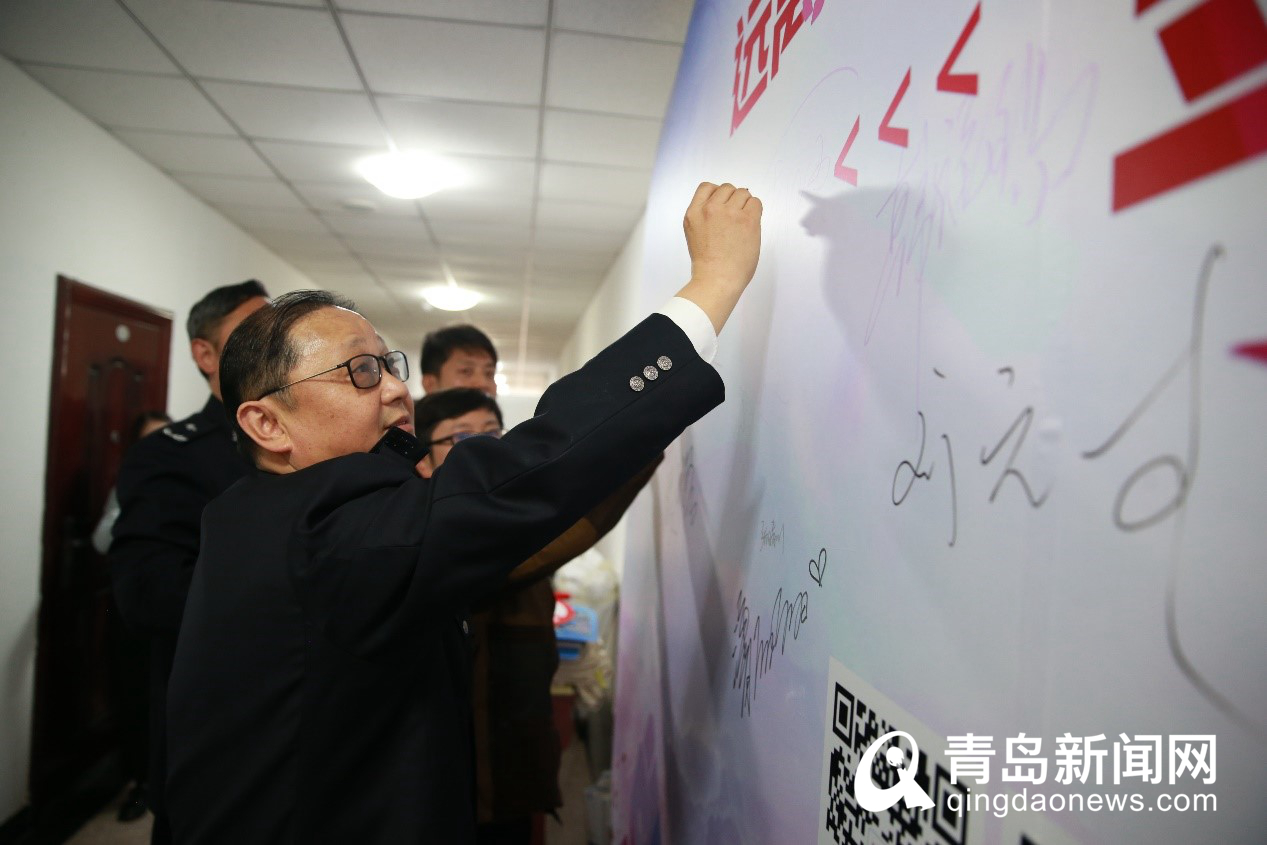 青岛市公安局经济犯罪侦查支队一大队大队长周江山在签名墙上签名